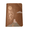 Notebook with a lighthouse and moon design on a brown background