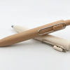 Two pens, one beige and one white, on a light gray background
